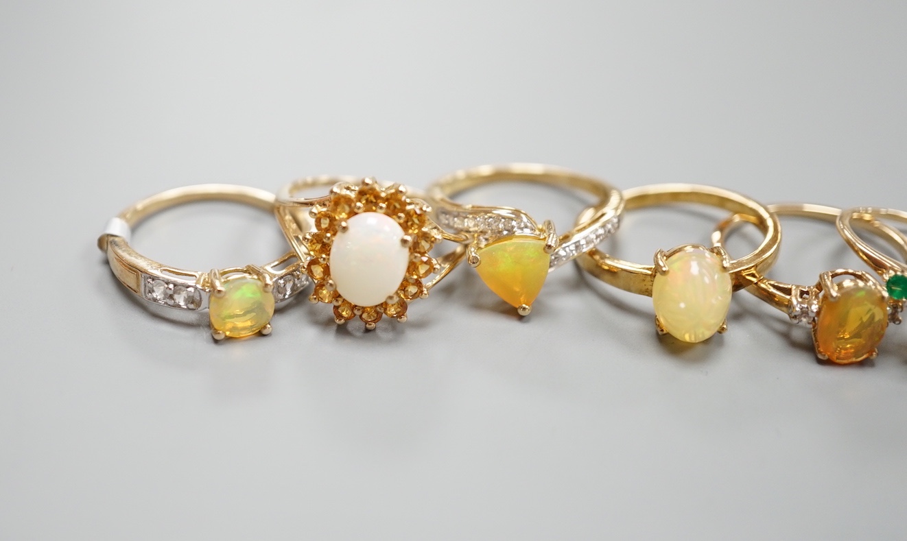 Seven assorted modern 9ct gold, opal and gem set dress rings, gross 14.6 grams and a 925 ring.